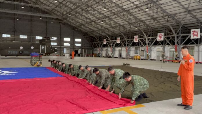 Die große Nationalflagge wird sorgfältig aufgerollt (Foto: RTI)